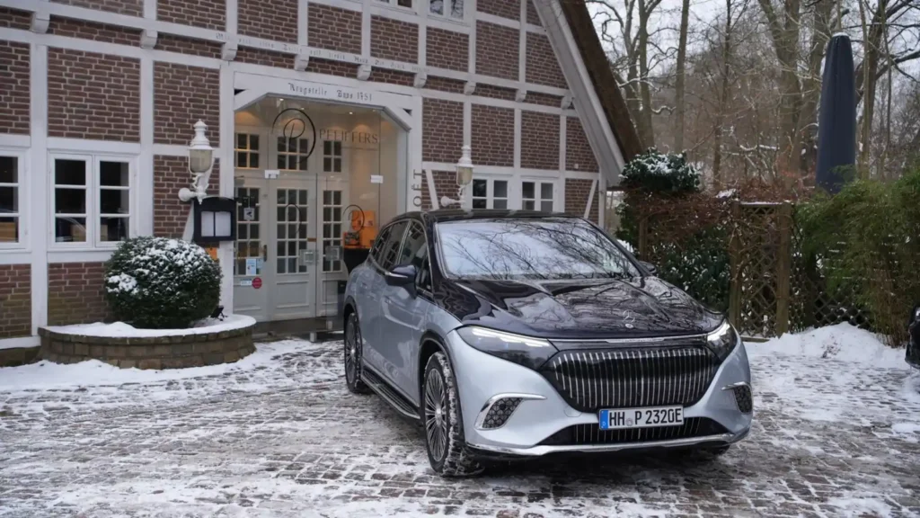 Mercedes-Maybach EQS SUV vor historischem Reetdachhaus in winterlicher Umgebung